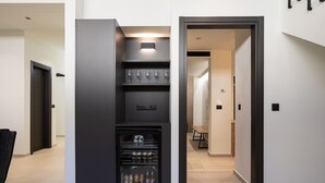 A modern kitchen with a built-in refrigerator, wine glasses, and a seating area with a table and chairs. - Villa Kafkales | Heated Pool (Chania)
