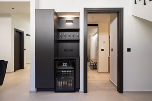 A modern kitchen with a built-in refrigerator, wine glasses, and a seating area with a table and chairs.
