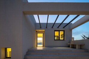 A modern building with a flat roof, large windows, and a set of steps leading to an entrance.