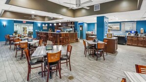 A spacious restaurant with multiple dining tables and chairs, a bar area, and a kitchen in the background. - Oceanfront King Bed 2BR 2BA Condo with WD Kitchen (North Myrtle Beach)