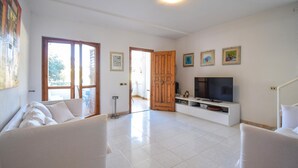 A living room with a sofa, TV, and artwork on the wall. - 3 bedroom cozy home in Lavinio (Lavinio)
