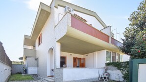 A two-story house with a flat roof, a small front yard, and a paved driveway. - 3 bedroom cozy home in Lavinio (Lavinio)