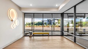 A modern interior with large windows, a bench, and a wall-mounted light fixture. - Echo Suites Extended Stay Reno (Reno)
