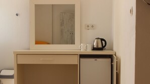 A compact kitchenette with a small refrigerator, a coffee maker, and a mirror above it. - Aydın Motel (Marmara)