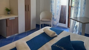 A hotel room with a bed, a desk, a chair, and a small table. - Le perle d'italia (Ravello)