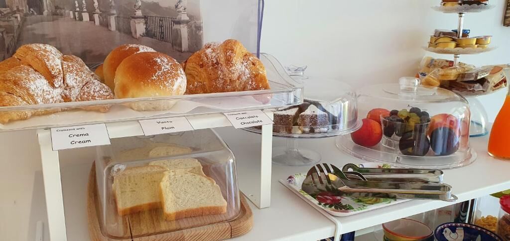 A bakery display with various pastries and a sandwich board.