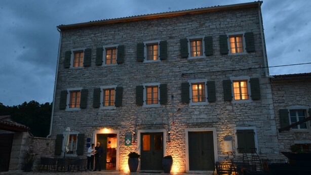 A stone building with multiple windows and doors, featuring a gravel courtyard and outdoor seating. - Tranquil Getaway With Shared Pool in Bale (Bale)