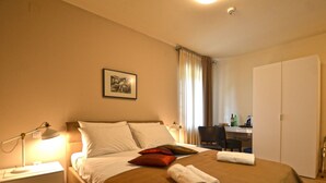A hotel room with a bed, a desk, a chair, a lamp, and a wardrobe. - Tranquil Getaway With Shared Pool in Bale (Bale)