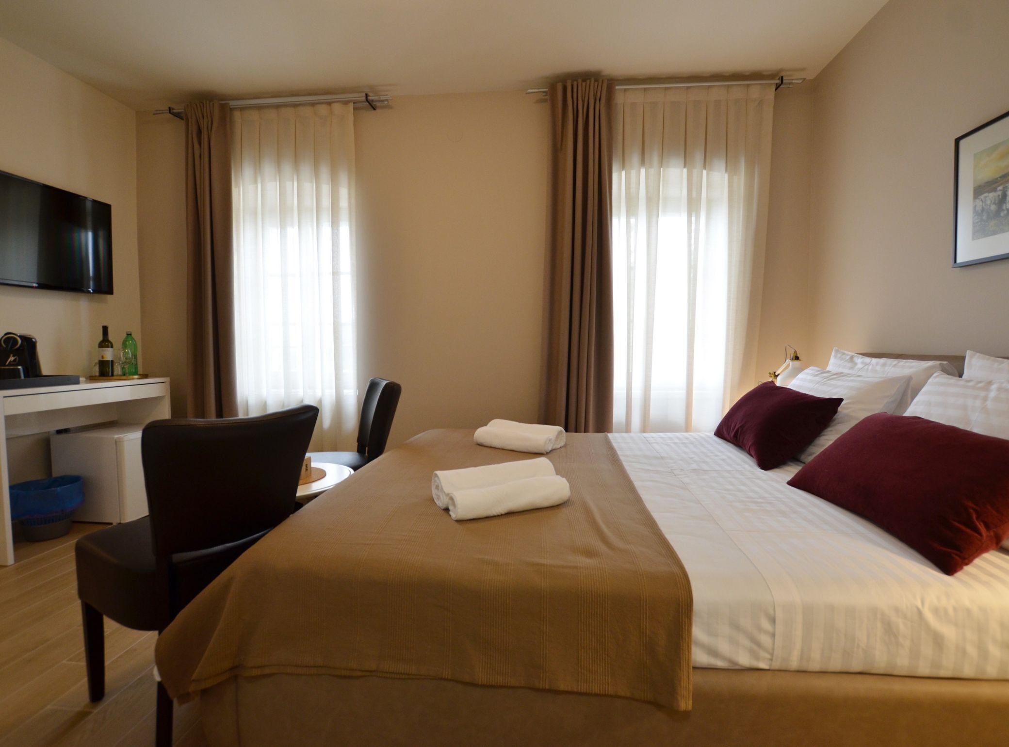 Een hotelkamer met een bed, een bureau, een stoel en een televisie.