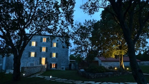 A stone building with multiple windows and a red door, surrounded by trees and a stone pathway. - Tranquil Getaway With Shared Pool in Bale (Bale)