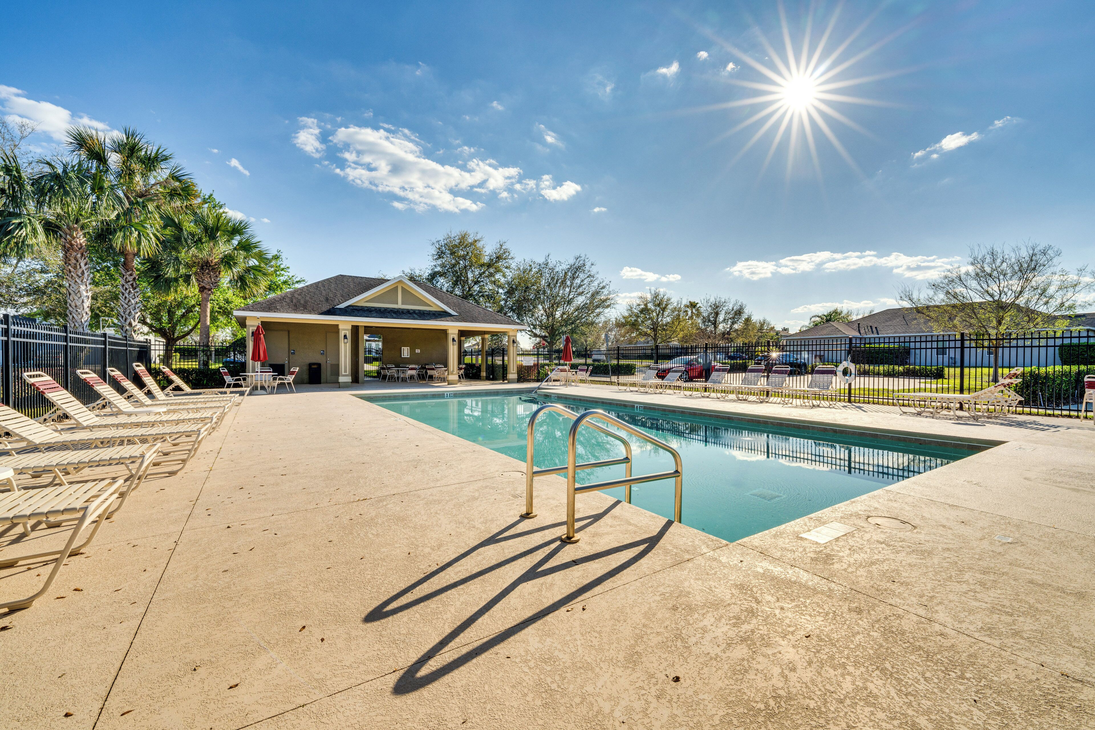 Ein Pool mit Liegestühlen und einer überdachten Sitzgelegenheit.