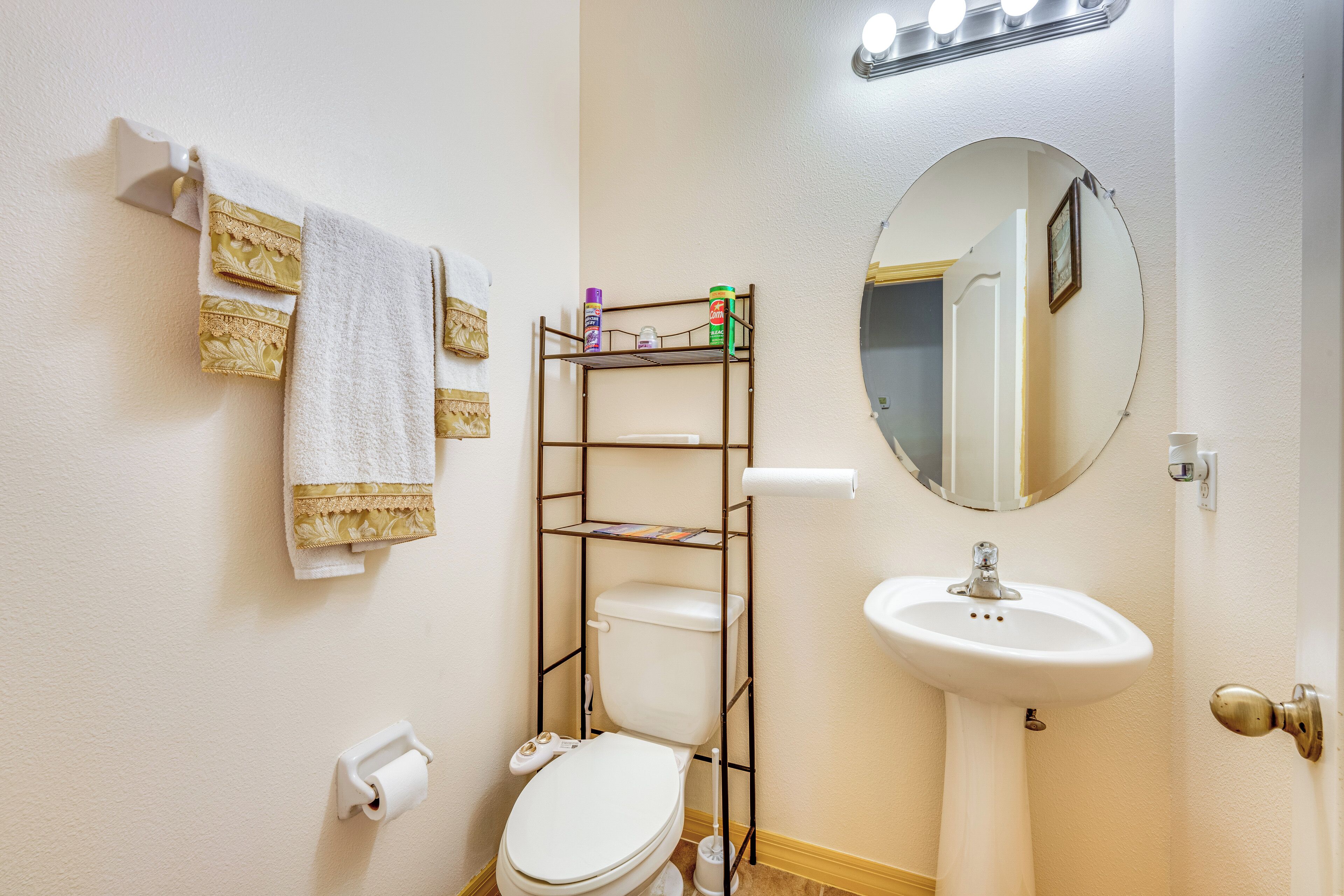 Een badkamer met toilet, wastafel en een plank met toiletartikelen.