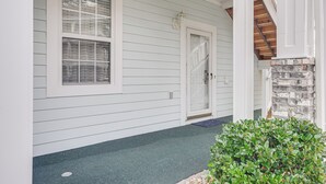 A house with a front porch, a door, and a window.