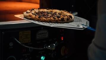 A pizza inside a brick oven with a digital control panel.