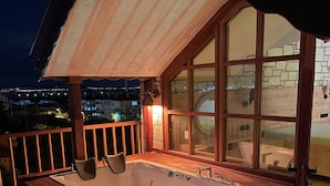 A hot tub on a balcony with a view of the city at night. - ACC Olives Luxury Boutique Hotel (Edremit)