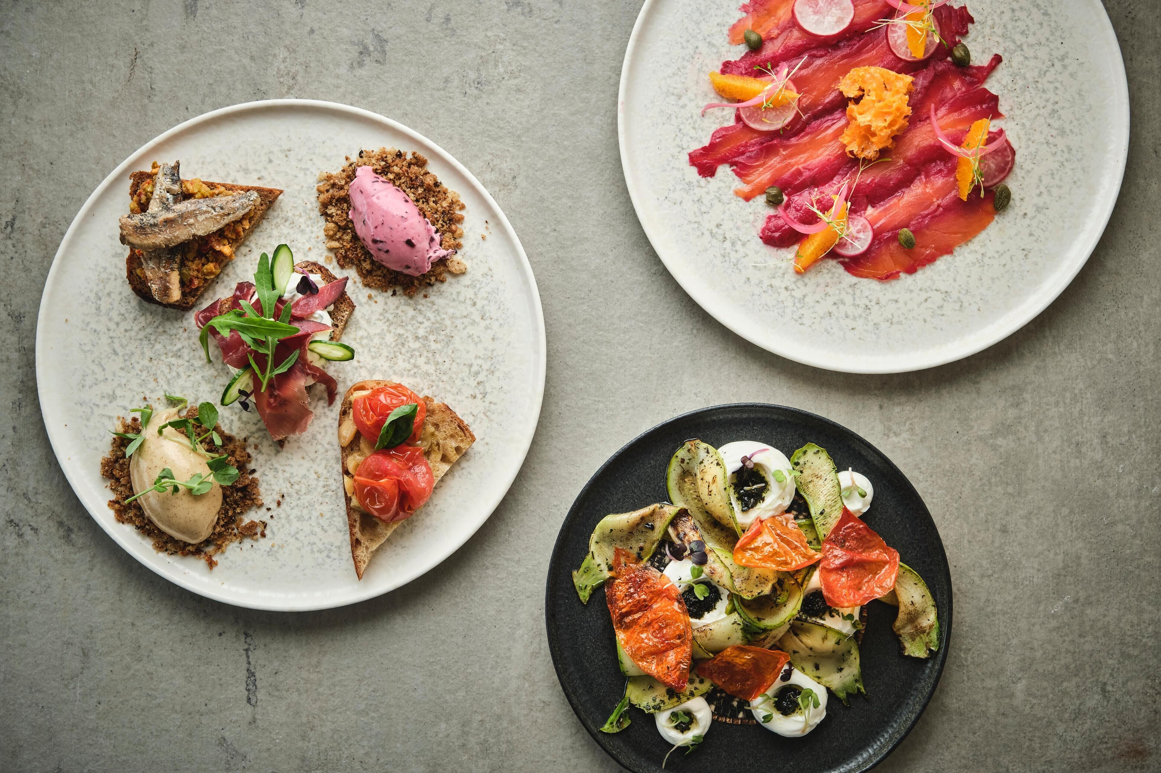 Three plates of food with various toppings and garnishes.