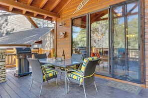 An outdoor patio with a grill, wicker chairs, and a glass table. - Rustic Retreat w/ Spacious Deck in Show Low! (Show Low)