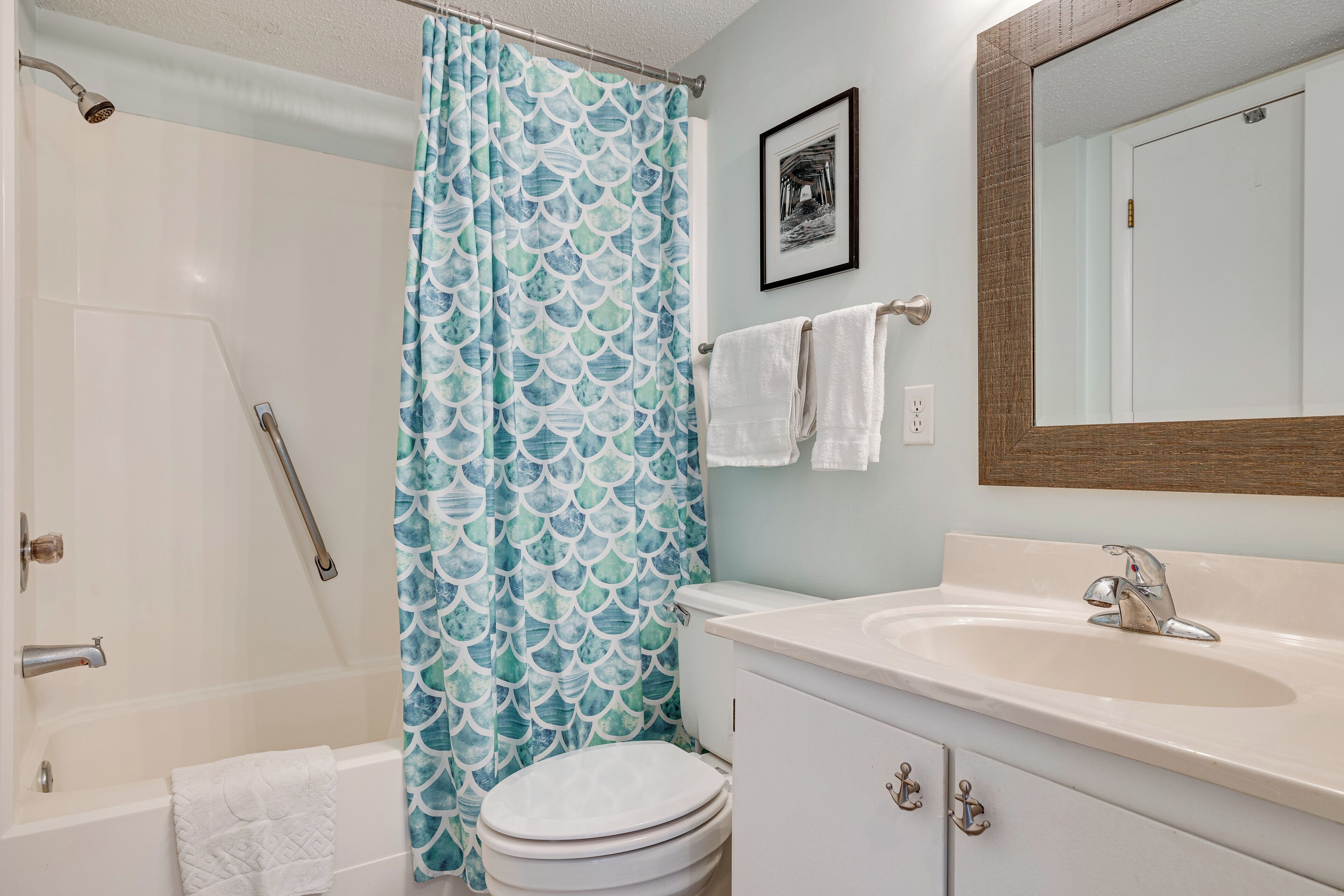 A bathroom with a bathtub, toilet, sink, and shower curtain.