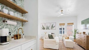 Una cocina moderna con armarios blancos, una cafetera y un salpicadero decorativo.