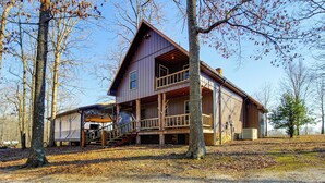 A two-story log cabin with a porch and a staircase leading to the upper level. - Reel in Fish, Relax By Fire: Mcminnville Cabin (McMinnville)