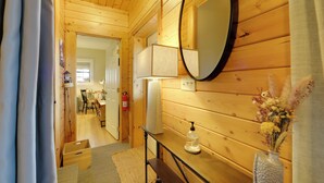 A wooden-paneled room with a mirror, a bench, a vase with flowers, and a fire extinguisher. - Secluded Mtn-view Retreat in Mars Hill (Mars Hill)