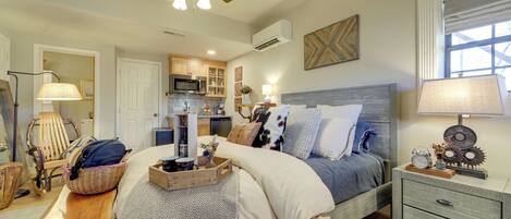 A bedroom with a bed, bedside table, nightstand, and ceiling fan.
