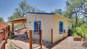 A single-story building with a fenced yard, a covered patio, and a small garden area. - Peaceful & Historic Home in Patagonia! (Patagonia)