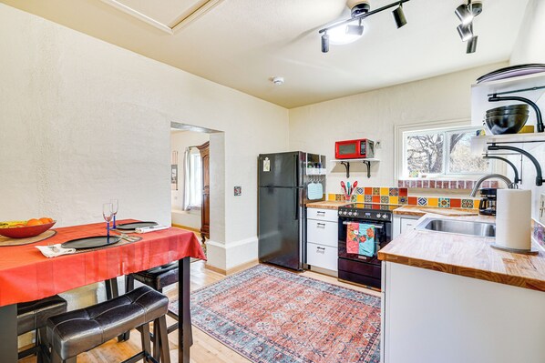 A compact kitchen with a dining area, a refrigerator, a microwave, and a sink. - Peaceful & Historic Home in Patagonia! (Patagonia)