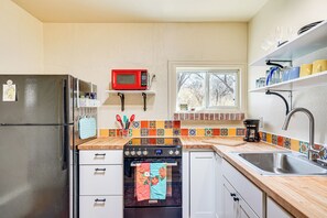A kitchen with a refrigerator, microwave, oven, and sink. - Peaceful & Historic Home in Patagonia! (Patagonia)