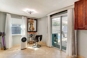 A hair salon with a large window, a ceiling fan, and a chair. - 8 Mi to Sunset Beach: Home w/ Large Patio + Pool! (New Port Richey)
