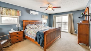 A bedroom with a wooden bed, a nightstand, a dresser, and a ceiling fan. - The Gathering Place: Rushville Home w/ Hot Tub (Rushville)