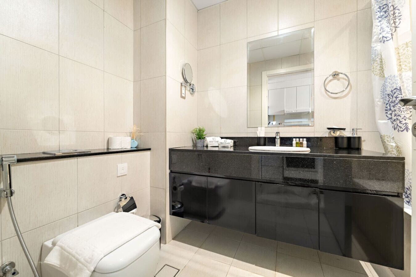 Een moderne badkamer met toilet, wastafel en douche.