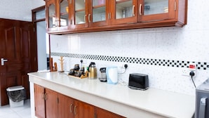 A kitchen with wooden cabinets, a white countertop, and a tiled backsplash.