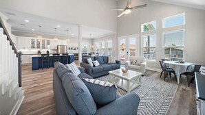 Amplia sala de estar con cocina moderna, comedor y balcón con vistas.