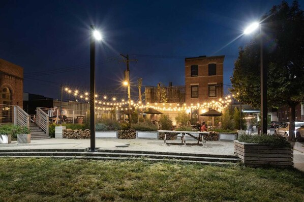 An outdoor dining area with string lights, a staircase, and a building in the background. - Art-inspired Philly Getaway (Philadelphia)