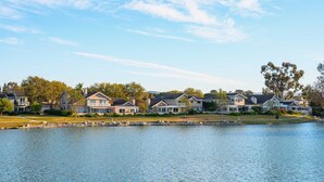 A lakeside residential area with houses, a dock, and a clear sky. - Waterfront Retreat With Stunning Views Modern Co (Santa Ana)