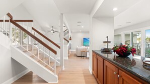 A modern kitchen with wooden cabinets, a granite countertop, and a large window. - Waterfront Retreat With Stunning Views Modern Co (Santa Ana)