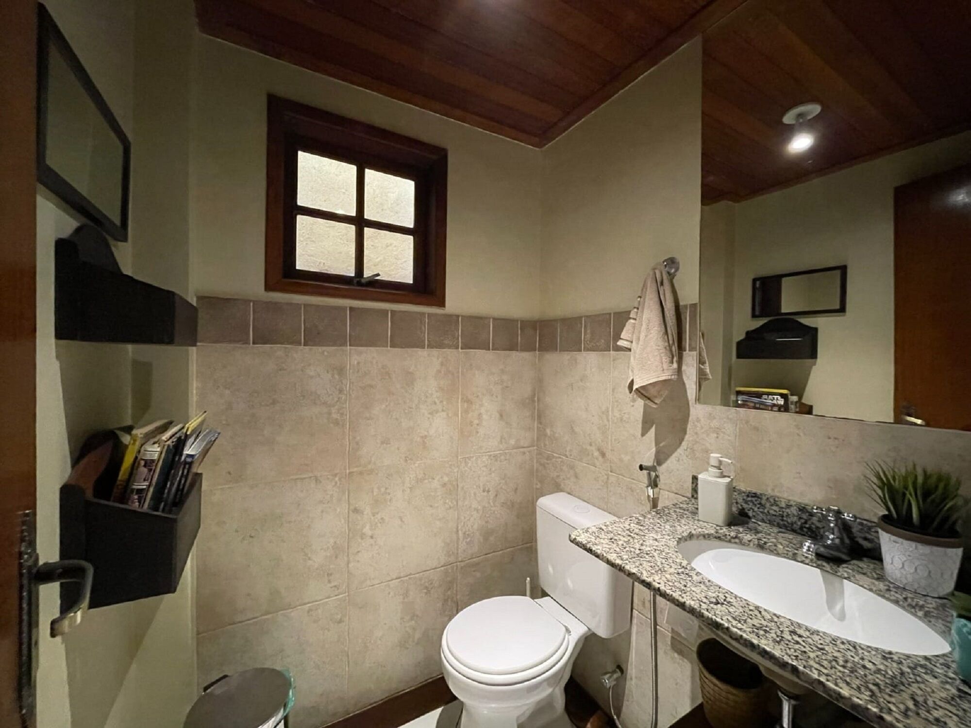 A bathroom with a toilet, sink, and window.