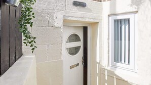 A white door with a circular window, a small window with vertical bars, and a sign above the door. - The Hamlet - North East Escapes (North Shields)