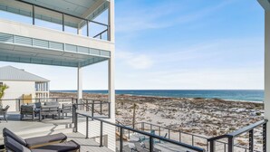 A rooftop terrace with a pool, lounge chairs, and a view of the beach and ocean.