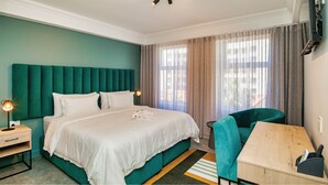 A hotel room with a large bed, a desk, a chair, and a window with curtains. - 9 On Barrack (Cape Town)