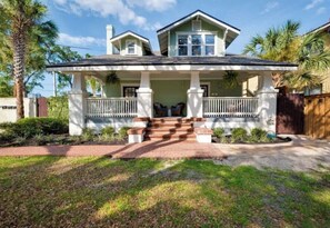 A two-story house with a porch, a front yard, and a driveway. - Charming 3-bedroom loft unit  with WiFi and AC in the Heart of San Marco (Jacksonville)