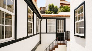 A white building with black trim, a staircase, and multiple windows. - Casa Los Profesores · Traditional Canarian Charm (La Orotava)