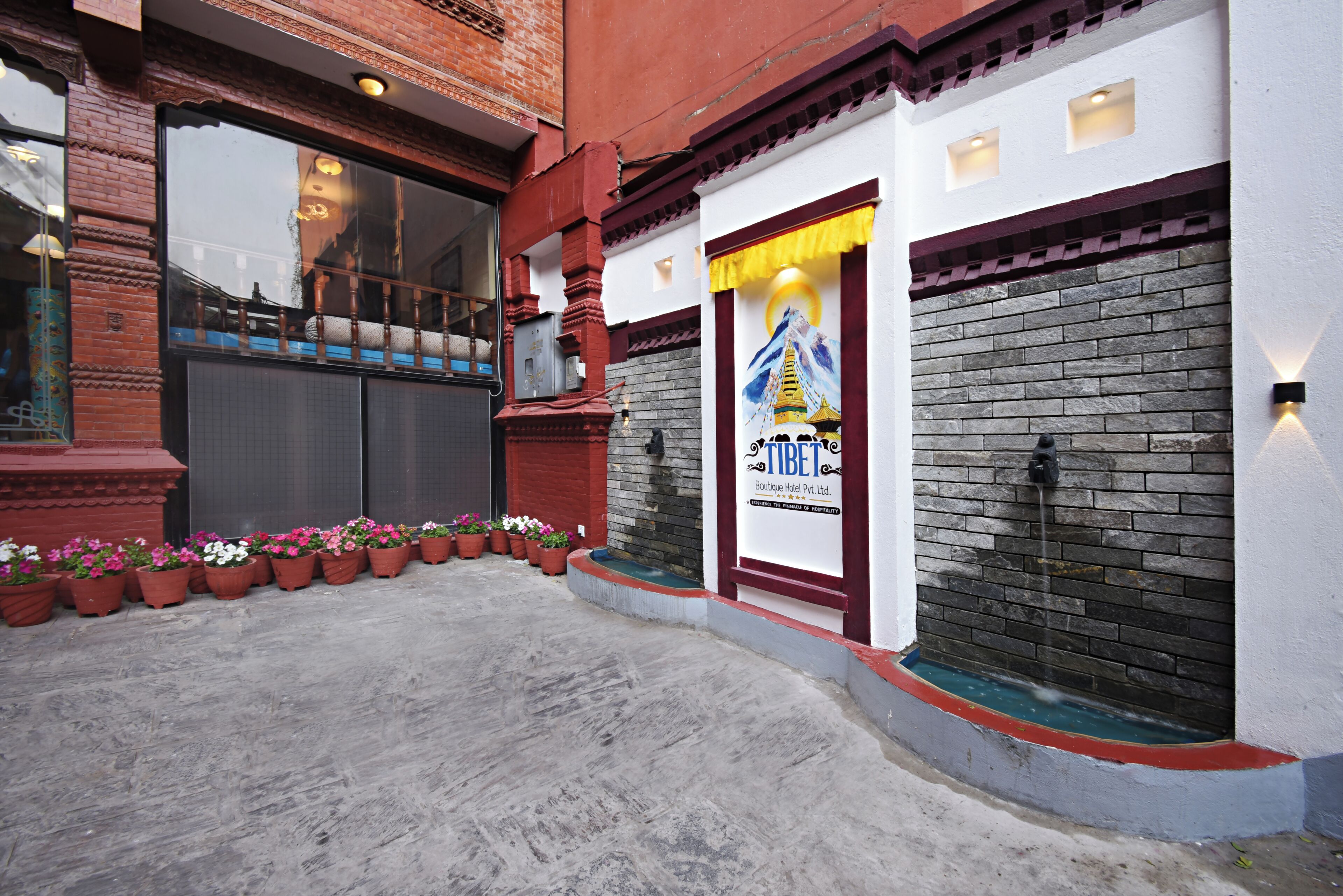 Un hotel boutique con fachada de ladrillo, un ventanal grande y un cartel.