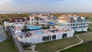 A large resort with multiple buildings, a central pool, and a boardwalk. - Parrot House-Ocean Side @ Pointe West-Close to walkover. 5BD/3Ba. Sleeps 15 (Galveston)