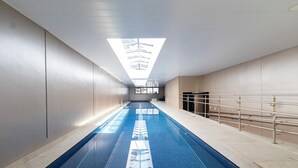 A long, narrow indoor swimming pool with a skylight overhead. - HUB Alto da Boa Vista (Sao Paulo)
