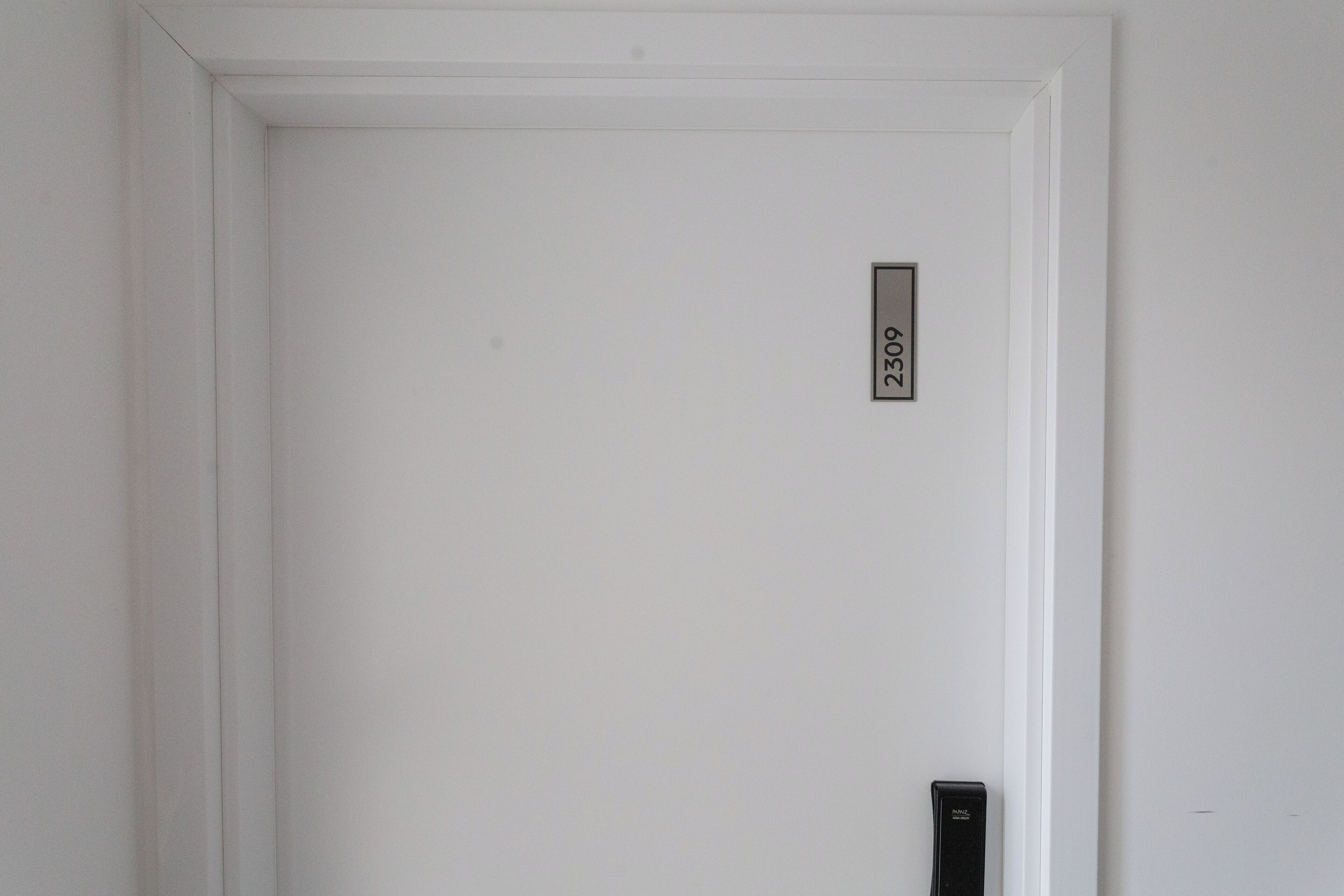 A white door with a small rectangular sign that reads "2309".