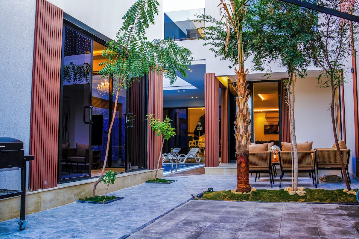 A modern outdoor area with a seating area, a small pool, and a well-maintained garden.