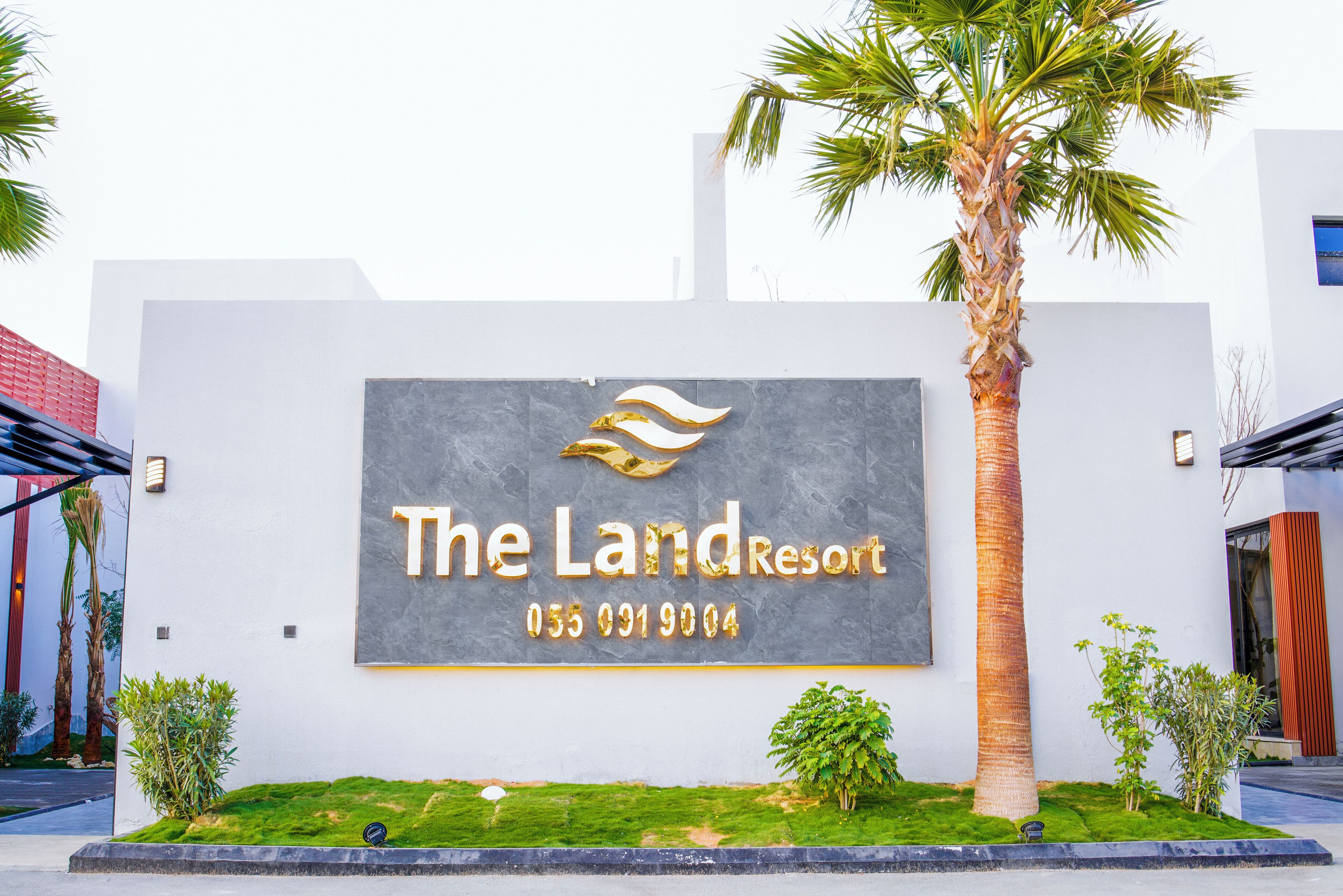 A sign for The Land Resort with a contact number.