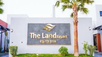 A sign for The Land Resort with a contact number.